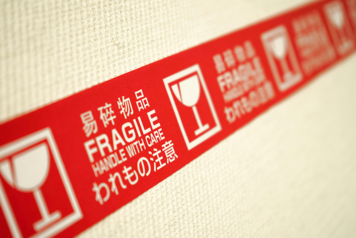 a red fragile label in English, Chinese, and Japanese on a white box