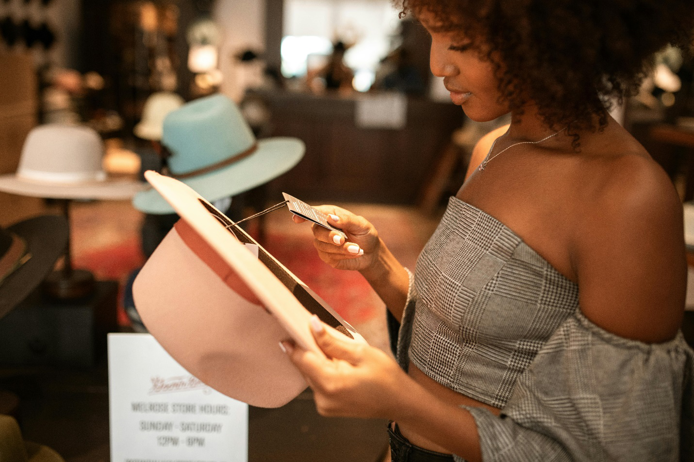 A picture of a person looking at the price tag of a cap 